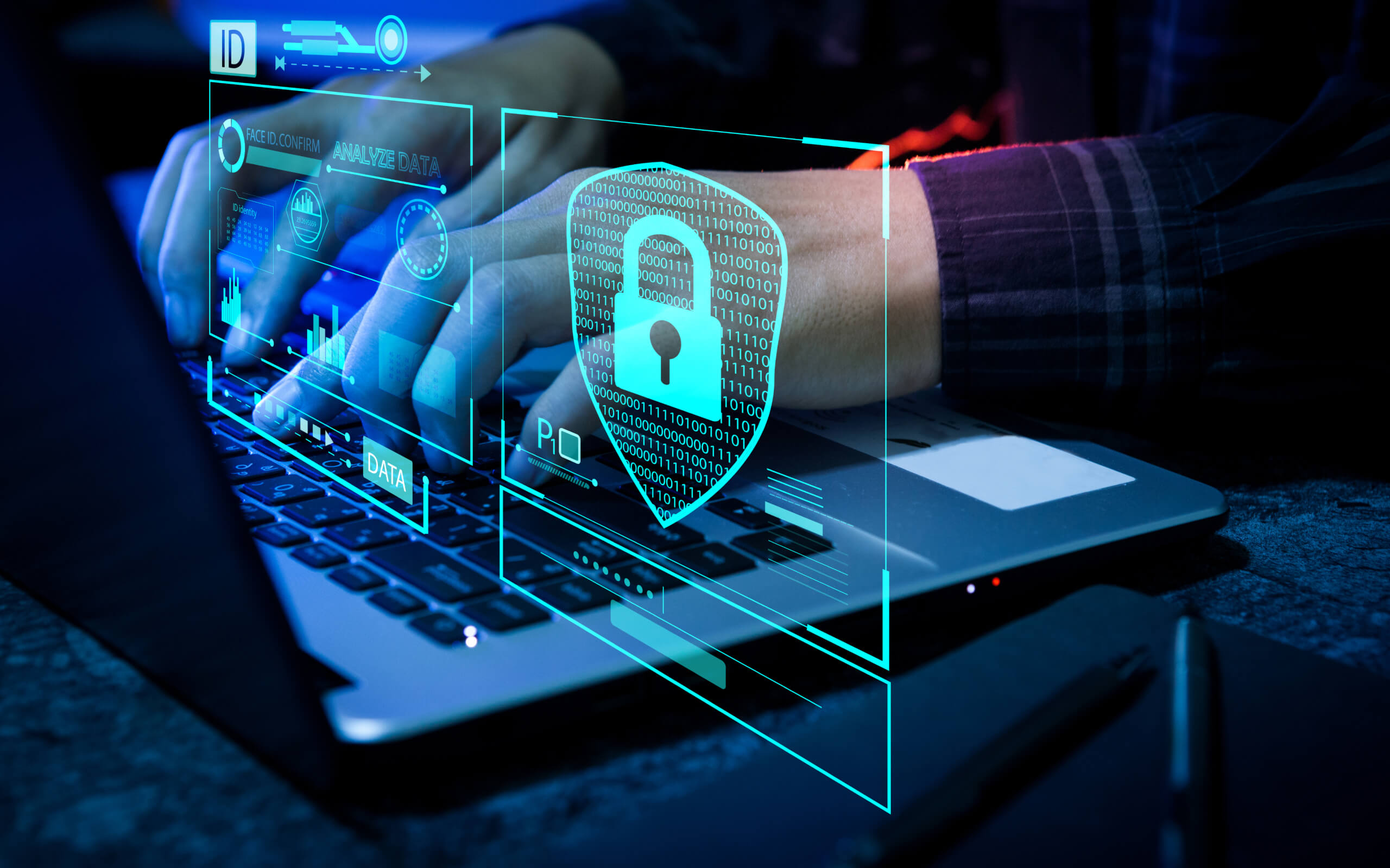 Hands typing on laptop with digital security graphics.