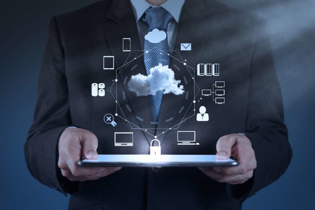 Businessman holding tablet with cloud computing icons.